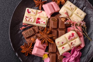 Çok renkli çikolatalar pembe, beyaz, kahverengi, koyu beton arka plan