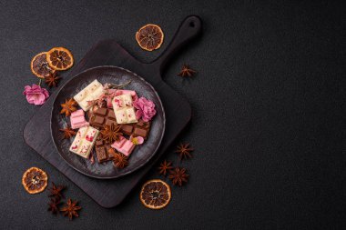 Çok renkli çikolatalar pembe, beyaz, kahverengi, koyu beton arka plan