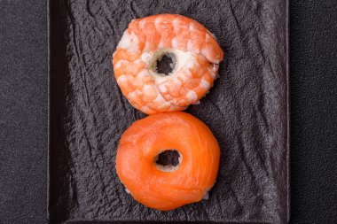 Somon, karides, ton balığı, tuz, baharat ve soya soslu donut şeklinde suşi ruloları.