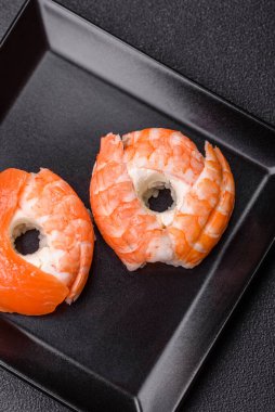 Somon, karides, ton balığı, tuz, baharat ve soya soslu donut şeklinde suşi ruloları.