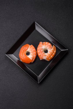 Somon, karides, ton balığı, tuz, baharat ve soya soslu donut şeklinde suşi ruloları.