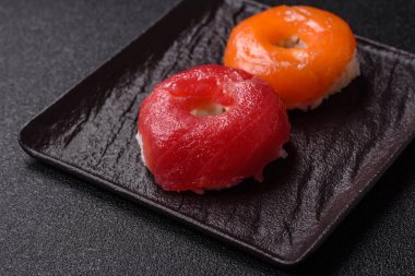 Somon, karides, ton balığı, tuz, baharat ve soya soslu donut şeklinde suşi ruloları.