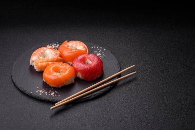 Somon, karides, ton balığı, tuz, baharat ve soya soslu donut şeklinde suşi ruloları.