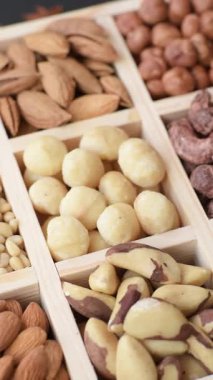 Ahşap bir kutunun içinde macadamia, çam, kaju, fındık, fıstık ve fıstık karışımı.