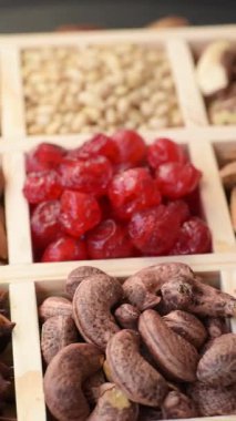 Ahşap bir kutunun içinde macadamia, çam, kaju, fındık, fıstık ve fıstık karışımı.