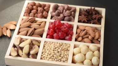 Ahşap bir kutunun içinde macadamia, çam, kaju, fındık, fıstık ve fıstık karışımı.