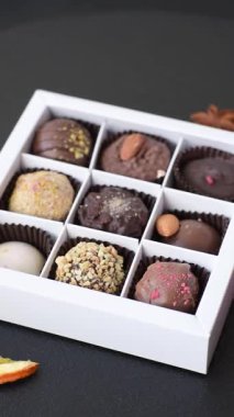 Koyu beton arka planda farklı dolgu ve serpiştirilmiş ev yapımı çikolatalı şekerler.