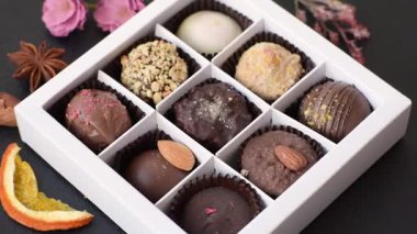 Koyu beton arka planda farklı dolgu ve serpiştirilmiş ev yapımı çikolatalı şekerler.