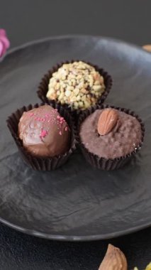 Koyu beton arka planda farklı dolgu ve serpiştirilmiş ev yapımı çikolatalı şekerler.