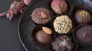 Koyu beton arka planda farklı dolgu ve serpiştirilmiş ev yapımı çikolatalı şekerler.