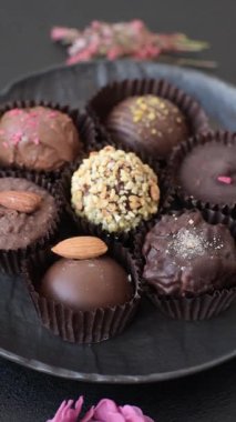 Koyu beton arka planda farklı dolgu ve serpiştirilmiş ev yapımı çikolatalı şekerler.