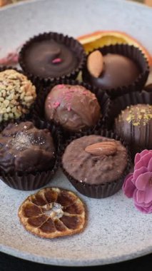 Koyu beton arka planda farklı dolgu ve serpiştirilmiş ev yapımı çikolatalı şekerler.