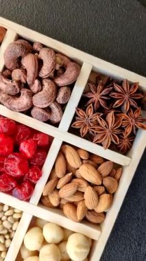 Ahşap bir kutunun içinde macadamia, çam, kaju, fındık, fıstık ve fıstık karışımı.