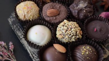 Koyu beton arka planda farklı dolgu ve serpiştirilmiş ev yapımı çikolatalı şekerler.