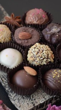 Koyu beton arka planda farklı dolgu ve serpiştirilmiş ev yapımı çikolatalı şekerler.