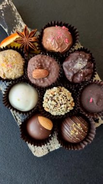 Koyu beton arka planda farklı dolgu ve serpiştirilmiş ev yapımı çikolatalı şekerler.