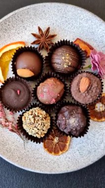 Koyu beton arka planda farklı dolgu ve serpiştirilmiş ev yapımı çikolatalı şekerler.