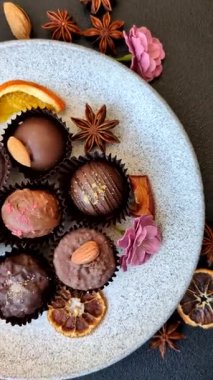 Koyu beton arka planda farklı dolgu ve serpiştirilmiş ev yapımı çikolatalı şekerler.