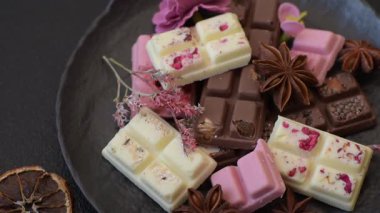 Çok renkli çikolatalar pembe, beyaz, kahverengi, koyu beton arka plan