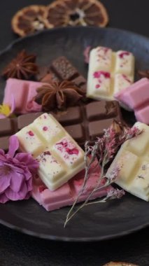 Çok renkli çikolatalar pembe, beyaz, kahverengi, koyu beton arka plan