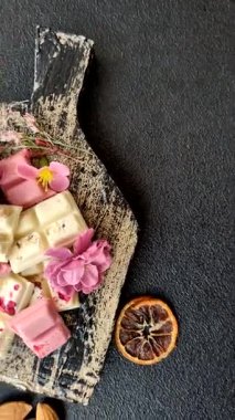 Çok renkli çikolatalar pembe, beyaz, kahverengi, koyu beton arka plan