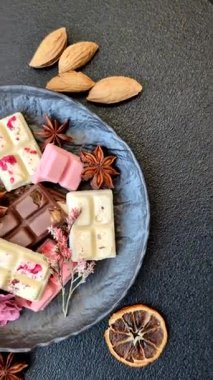 Çok renkli çikolatalar pembe, beyaz, kahverengi, koyu beton arka plan