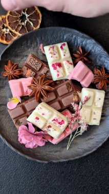 Çok renkli çikolatalar pembe, beyaz, kahverengi, koyu beton arka plan