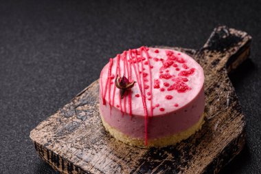 Koyu beton arka planda ahududu ya da çilekli tatlı yuvarlak tart peynirli kek.