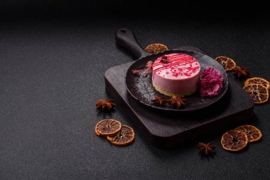 Koyu beton arka planda ahududu ya da çilekli tatlı yuvarlak tart peynirli kek.