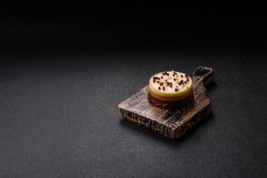 Tatlı yuvarlak turta. Koyu beton arka planda üç çikolata.