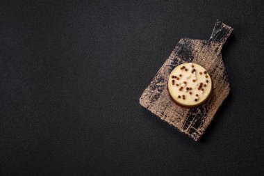 Tatlı yuvarlak turta. Koyu beton arka planda üç çikolata.