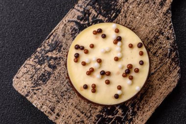 Tatlı yuvarlak turta. Koyu beton arka planda üç çikolata.