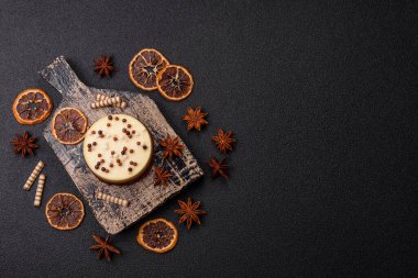 Tatlı yuvarlak turta. Koyu beton arka planda üç çikolata.