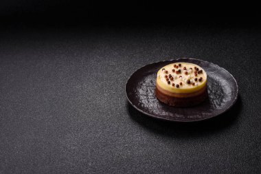 Tatlı yuvarlak turta. Koyu beton arka planda üç çikolata.