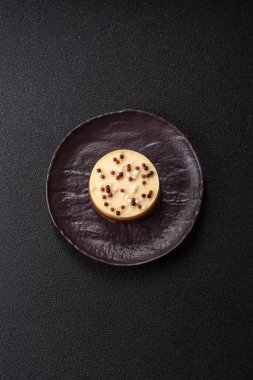 Tatlı yuvarlak turta. Koyu beton arka planda üç çikolata.