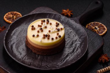 Tatlı yuvarlak turta. Koyu beton arka planda üç çikolata.