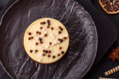 Tatlı yuvarlak turta. Koyu beton arka planda üç çikolata.