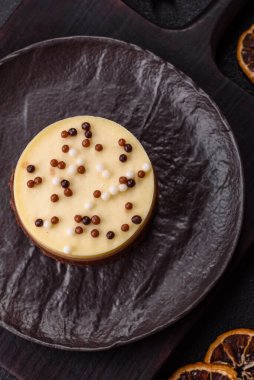 Tatlı yuvarlak turta. Koyu beton arka planda üç çikolata.