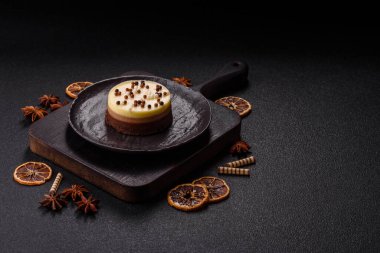 Tatlı yuvarlak turta. Koyu beton arka planda üç çikolata.