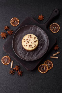 Tatlı yuvarlak turta. Koyu beton arka planda üç çikolata.