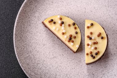 Tatlı yuvarlak turta. Koyu beton arka planda üç çikolata.