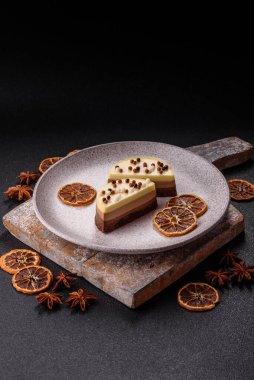 Tatlı yuvarlak turta. Koyu beton arka planda üç çikolata.