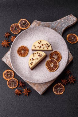 Tatlı yuvarlak turta. Koyu beton arka planda üç çikolata.