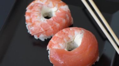 Somon, karides, ton balığı, tuz, baharat ve soya soslu donut şeklinde suşi ruloları.