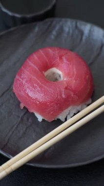 Somon, karides, ton balığı, tuz, baharat ve soya soslu donut şeklinde suşi ruloları.