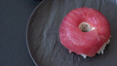 Somon, karides, ton balığı, tuz, baharat ve soya soslu donut şeklinde suşi ruloları.