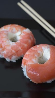 Somon, karides, ton balığı, tuz, baharat ve soya soslu donut şeklinde suşi ruloları.