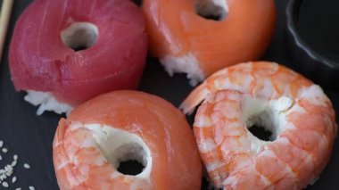 Somon, karides, ton balığı, tuz, baharat ve soya soslu donut şeklinde suşi ruloları.