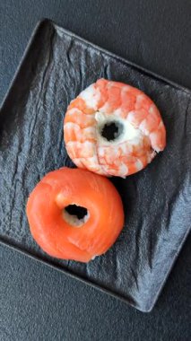 Somon, karides, ton balığı, tuz, baharat ve soya soslu donut şeklinde suşi ruloları.