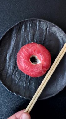 Somon, karides, ton balığı, tuz, baharat ve soya soslu donut şeklinde suşi ruloları.